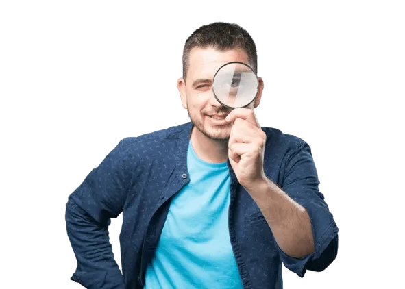 Mann mit blauer Jacke und T-Shirt, der eine große Lupe vor dem Gesicht hält und mit einem Auge durchschaut. Der Gesichtsausdruck wirkt sehr freundlich.